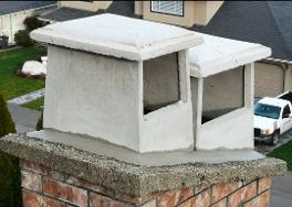 Two angled concrete raincaps on a chimney